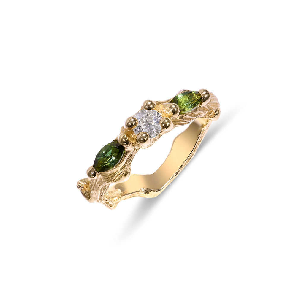 Gold ring with green gemstones and a diamond on a white background