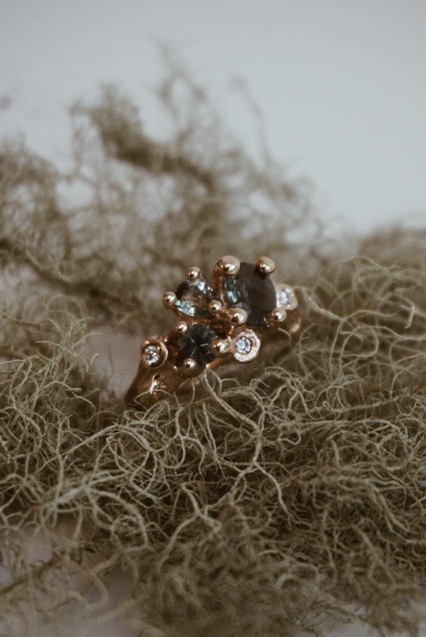 Yellow gold ring with gemstones on a textured surface