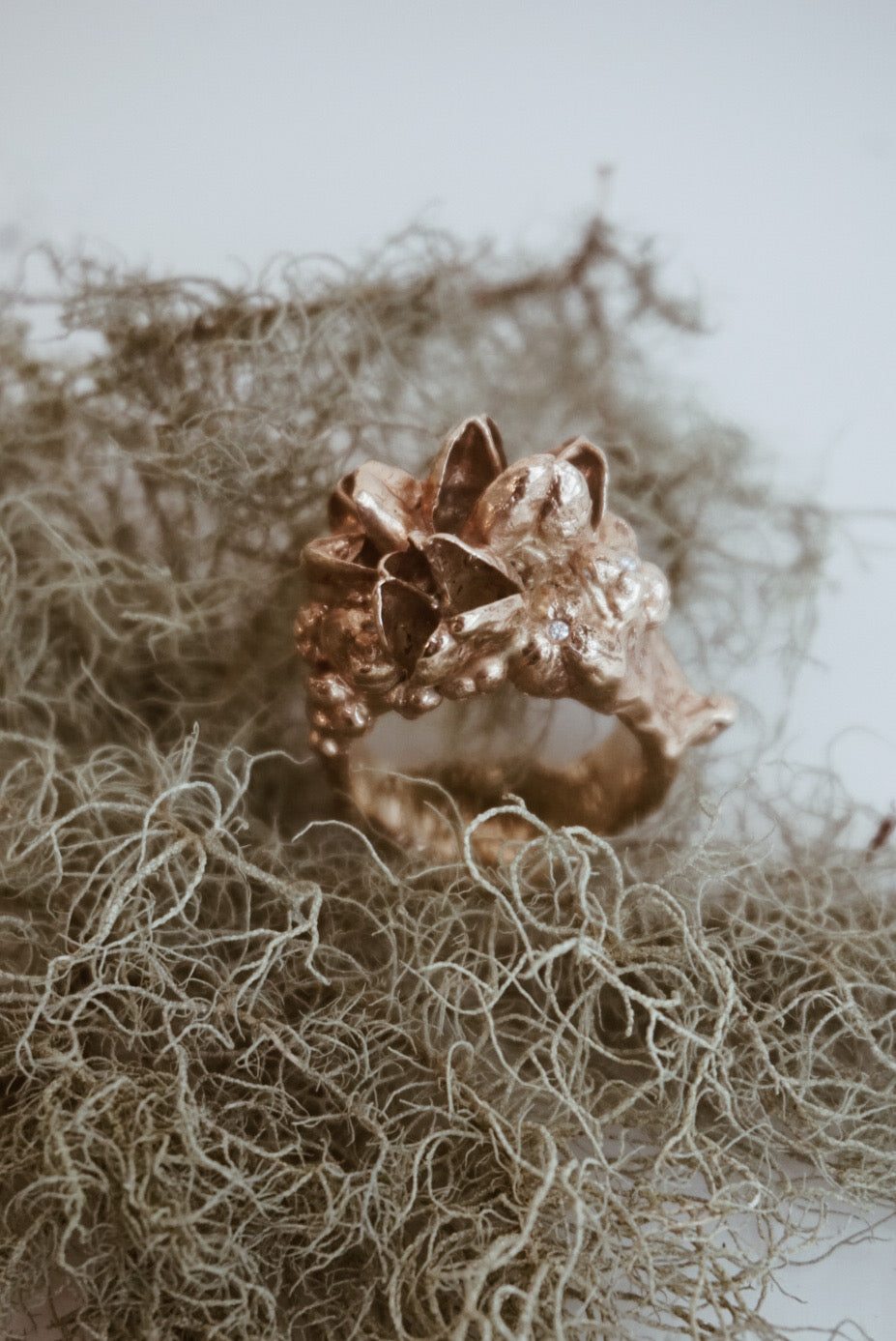 Yellow gold ring with a floral design on a textured surface