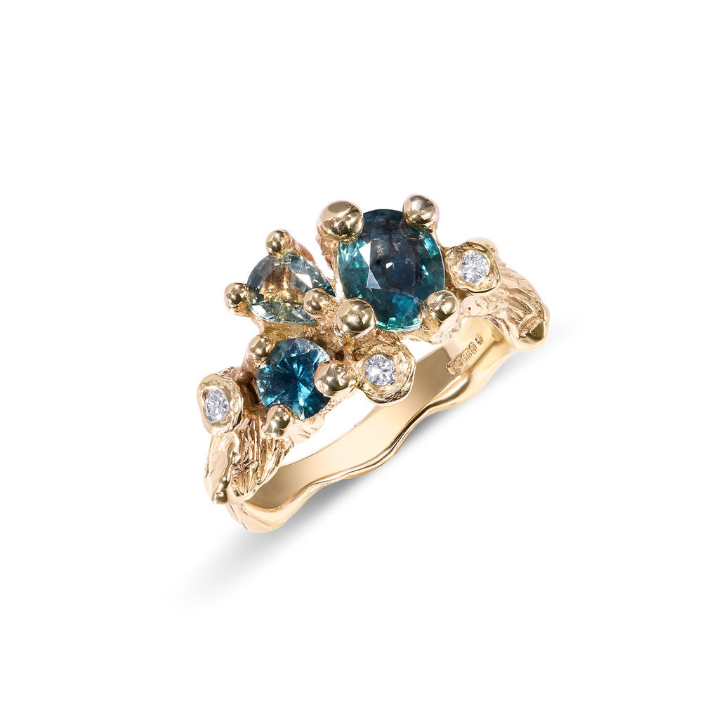 Gold ring with blue gemstones on a white background