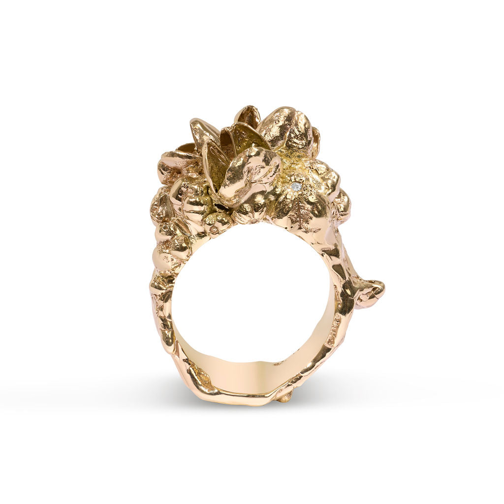 Gold ring with intricate design on a white background