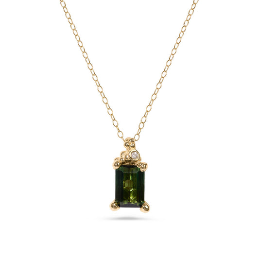 Gold necklace with a green gemstone pendant on a white background
