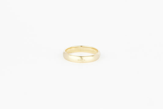 yellow gold wedding band with hallmark detail on white background.